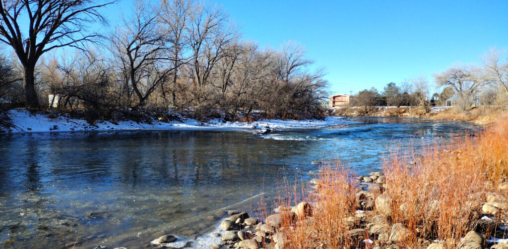 The Animas river flowing through Berg Park in Farmington, New Mexico in winter with snow on the banks