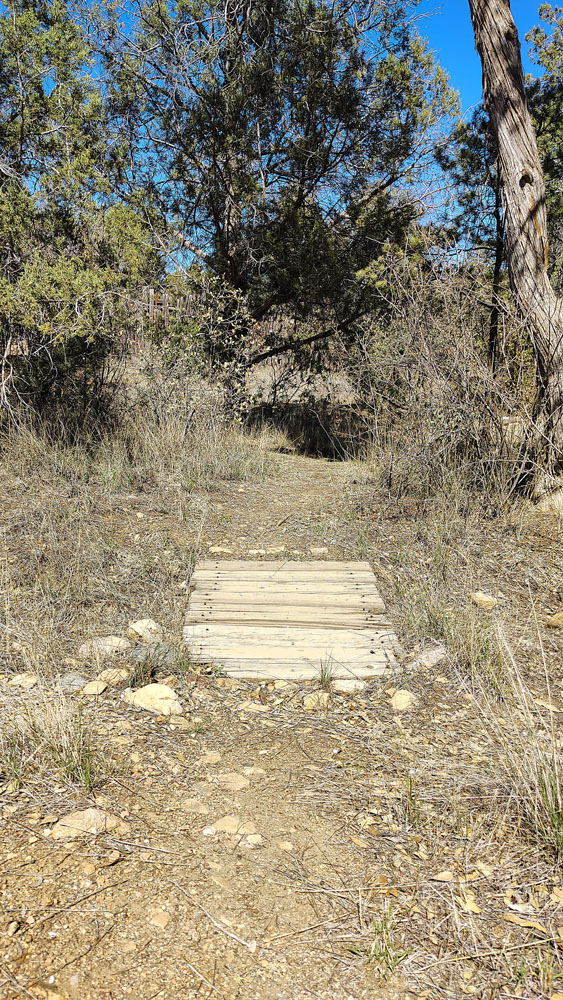 an old small wood bridge over a narrow dry stream
